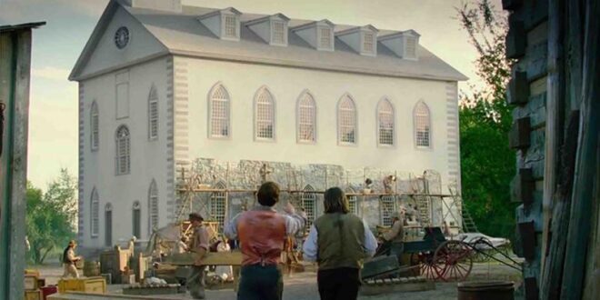 Two men observe a building under construction.