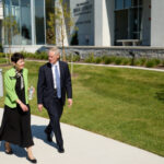 Two people walking outside a modern building.